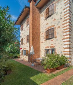 a brick building with a table and an umbrella at Villa Il Fortino in Lido di Camaiore