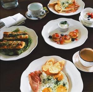 a table with plates of food and cups of coffee at Hotel Royal in Belgorod