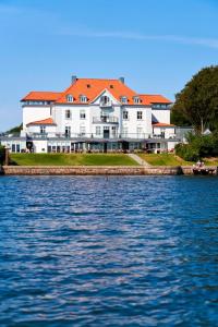 a large white building next to a large body of water at Sixtus Sinatur Hotel & Konference in Middelfart