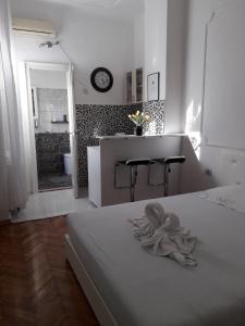 a white room with a bed and a kitchen at Apartment Dunja NS in Novi Sad