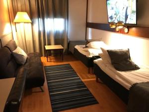 pokój hotelowy z 2 łóżkami i kanapą w obiekcie Hotel Carneval w mieście Suonenjoki