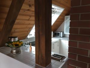 a kitchen with white cabinets and a brick wall at Ferienwohnung DAShaus in Rheinfelden