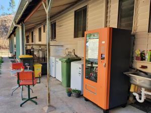 un apparecchio arancione e nero seduto fuori da un edificio di Meyenburg House a Mount Morgan