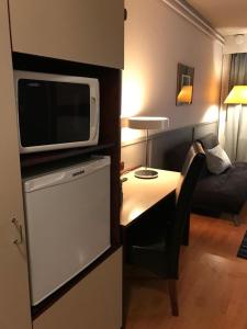 a small living room with a couch and a television at Hotel Carneval in Suonenjoki