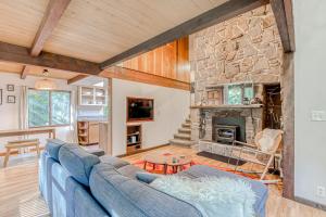 a living room with a blue couch and a stone fireplace at Rivers Perch in Washougal