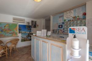 a kitchen with a sink, a refrigerator, and a painting on the wall at Residence Bouganvillage in Budoni