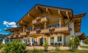 una gran casa de madera con balcones y flores en Mitterbichlhof, en Sankt Johann im Pongau