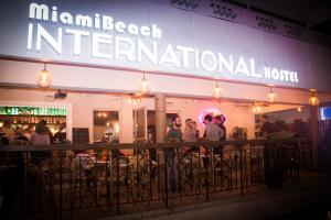 a group of people standing outside a restaurant at night at Miami International by Lowkl in Miami Beach