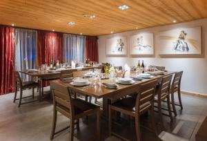 uma grande sala de jantar com uma mesa longa e cadeiras em Alaska Lodge em Morzine