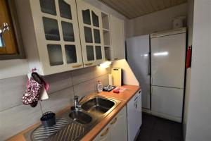 a small kitchen with a sink and a refrigerator at Pyhtään Vuokramökit in Tuuski