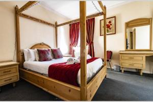 um quarto com uma cama de dossel e um espelho em OYO Paddington House Hotel em Warrington