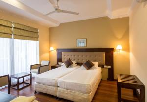 
a hotel room with two beds and two lamps at Devon Hotel in Kandy
