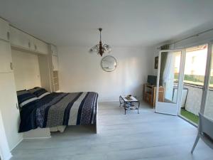 een witte slaapkamer met een bed en een raam bij Naïades 2 in La Baule