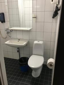 a bathroom with a white toilet and a sink at Hotel Carneval in Suonenjoki