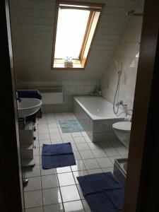 a bathroom with a tub and a sink and a bath tub at Ferienwohnung Familie Heigemeir in Ehekirchen