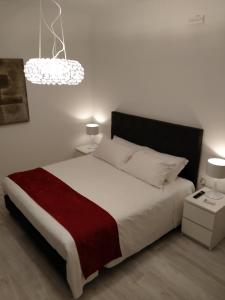 a bedroom with a large white bed with a red blanket at Villa Beatrice in Brescia