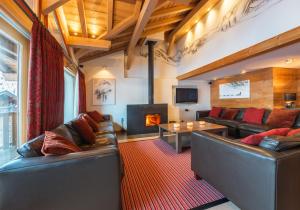 a living room with two leather couches and a fireplace at Alaska Lodge in Morzine