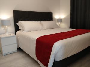 a bedroom with a large bed with a red blanket at Villa Beatrice in Brescia