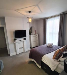 a bedroom with a bed and a flat screen tv at The Albert Hotel in Shrewsbury