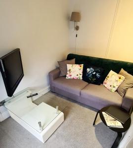 a living room with a couch and a tv at The Albert Hotel in Shrewsbury