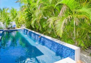 una piscina frente a algunas palmeras en Captain’s Quarters at Anna Maria Island Inn, en Bradenton Beach