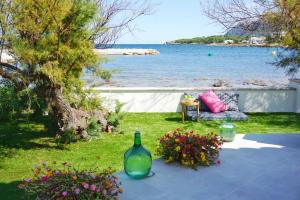 einen Garten mit einem Tisch mit Blumen und einer Flasche in der Unterkunft Seashore House " Es tamarells" in Alcúdia