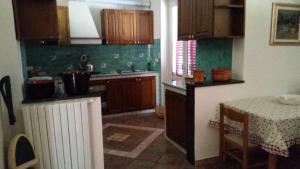 a kitchen with wooden cabinets and a table with a tableablish at La Vecchia Lanterna da Ines...... in Romagnano al Monte +6 photos