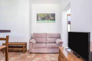 een woonkamer met een bank en een flatscreen-tv bij El Descanso Conil 1 in Conil de la Frontera