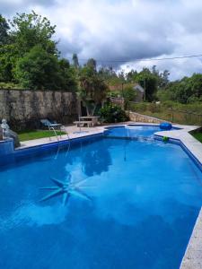 ein großer Pool mit blauem Wasser in der Unterkunft Casa Garabullo in Cepeda