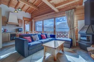 a living room with a blue couch and a table at Rose et Chardon Apartment - Snow and Trek - Morzine in Morzine