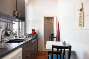 a kitchen with a sink and a table with chairs at Pigneto Life Nest in Rome