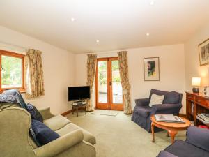 a living room with a couch and a tv at Granary Cottage in Shipston-on-Stour