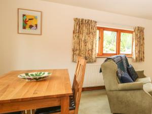 a dining room with a table and a chair at Granary Cottage in Shipston on Stour