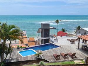 a house with a swimming pool next to the ocean at Pousada Ilha da Saudade in Morro de São Paulo