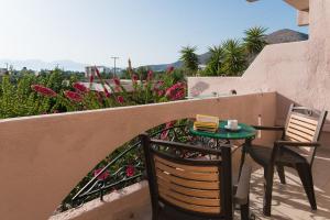 a table and chairs on a balcony with flowers at Olondio Apartments in Elounda