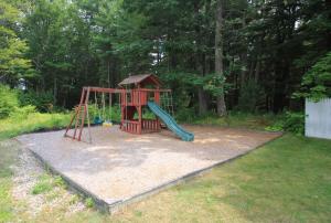 a playground with a slide in a yard at Wells-Ogunquit Resort Motel & Cottages in Ogunquit