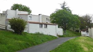 ein Haus an der Seite eines Hügels neben einer Straße in der Unterkunft Joli petit T4 confortable au bord de leau in Vieille-Brioude