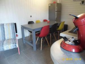 a kitchen with a table with chairs and a blender at Joli petit T4 confortable au bord de leau in Vieille-Brioude