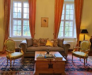 a living room with a couch and two chairs at Schloss Stülpe in Stülpe