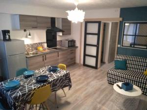 a kitchen and a living room with a table and chairs at Joli petit logement en centre ville de Brioude in Brioude