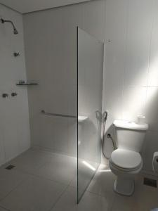 a bathroom with a toilet and a glass shower at Front Hotel Expominas in Belo Horizonte