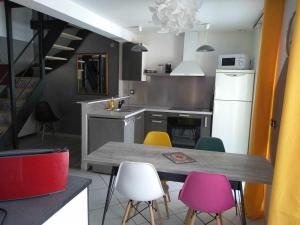 a kitchen with a table and colorful chairs at Agréable duplex au centre ville de Brioude in Brioude +25 photos