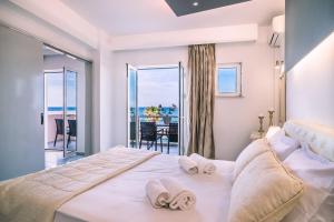 een slaapkamer met een groot bed en handdoeken bij Laplaya Beach in Malia