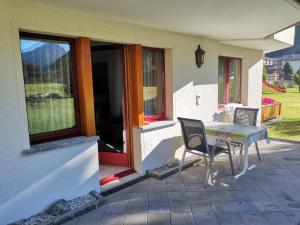 een tafel en stoelen buiten een huis bij Ferienhaus Antigua in Saas-Grund