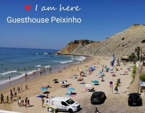 
a beach scene with people on the beach at Guesthouse Peixinho in Burgau
