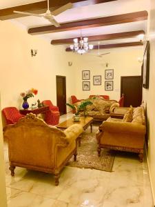 ein Wohnzimmer mit Sofas und einem Tisch und Stühlen in der Unterkunft Camellia Heritage Homestay in Jaipur