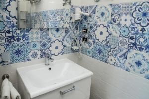 a bathroom with blue and white tiles on the wall at Hotel El Balear in Alghero
