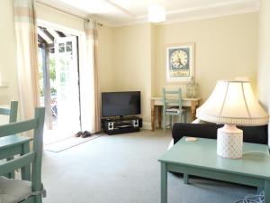 a living room with a couch and a tv at Secret Garden Hideaway For Adults in Eastbourne