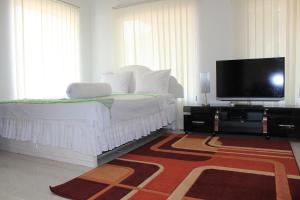 1 dormitorio con 1 cama y TV de pantalla plana en OMA Homestay, en Sawahlunto