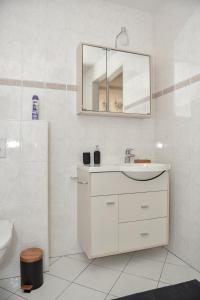 a white bathroom with a sink and a mirror at Levenslust Hulshorst in Hulshorst